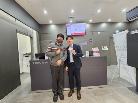 우주사무기 엔지니어가 바닥에 무릎을 꿇고 앉아 산업용 라벨프린터 내부를 점검하는 모습